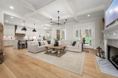 a kitchen with stainless steel appliances kitchen island granite countertop a stove a sink a dining table and chairs with wooden floor