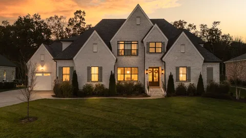 a dining room with wooden floor a chandelier a glass table and chairs