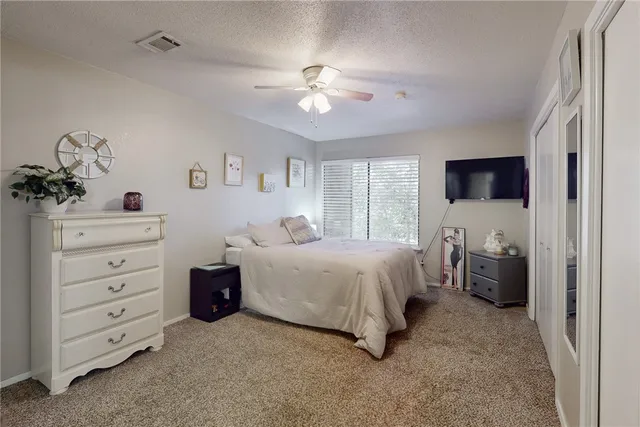 a spacious bedroom with a large bed and a chandelier