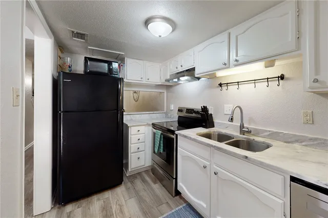 a kitchen with refrigerator and cabinets