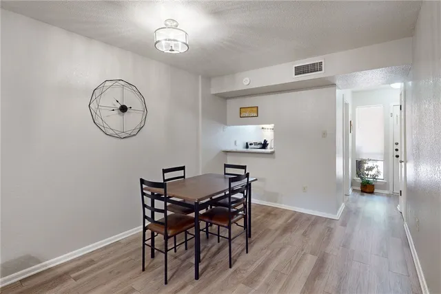 a view of a room with wooden floor a table and chairs