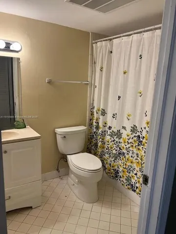 a bathroom with a granite countertop sink a toilet and a mirror