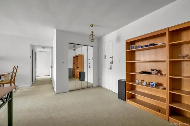 a view of an empty room with a cabinet and a window