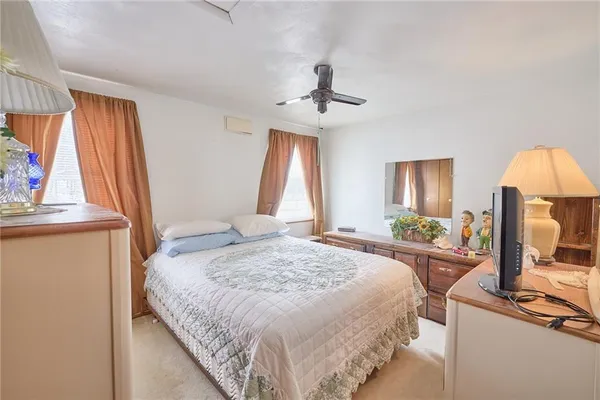 a spacious bedroom with a bed a flat screen tv and a large window