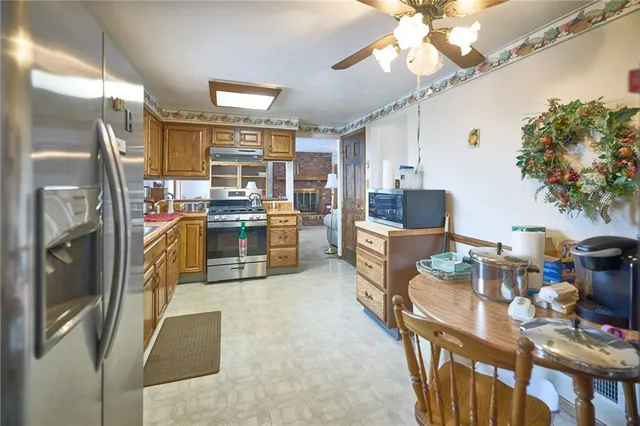 a kitchen with stainless steel appliances a stove a refrigerator and a dining table