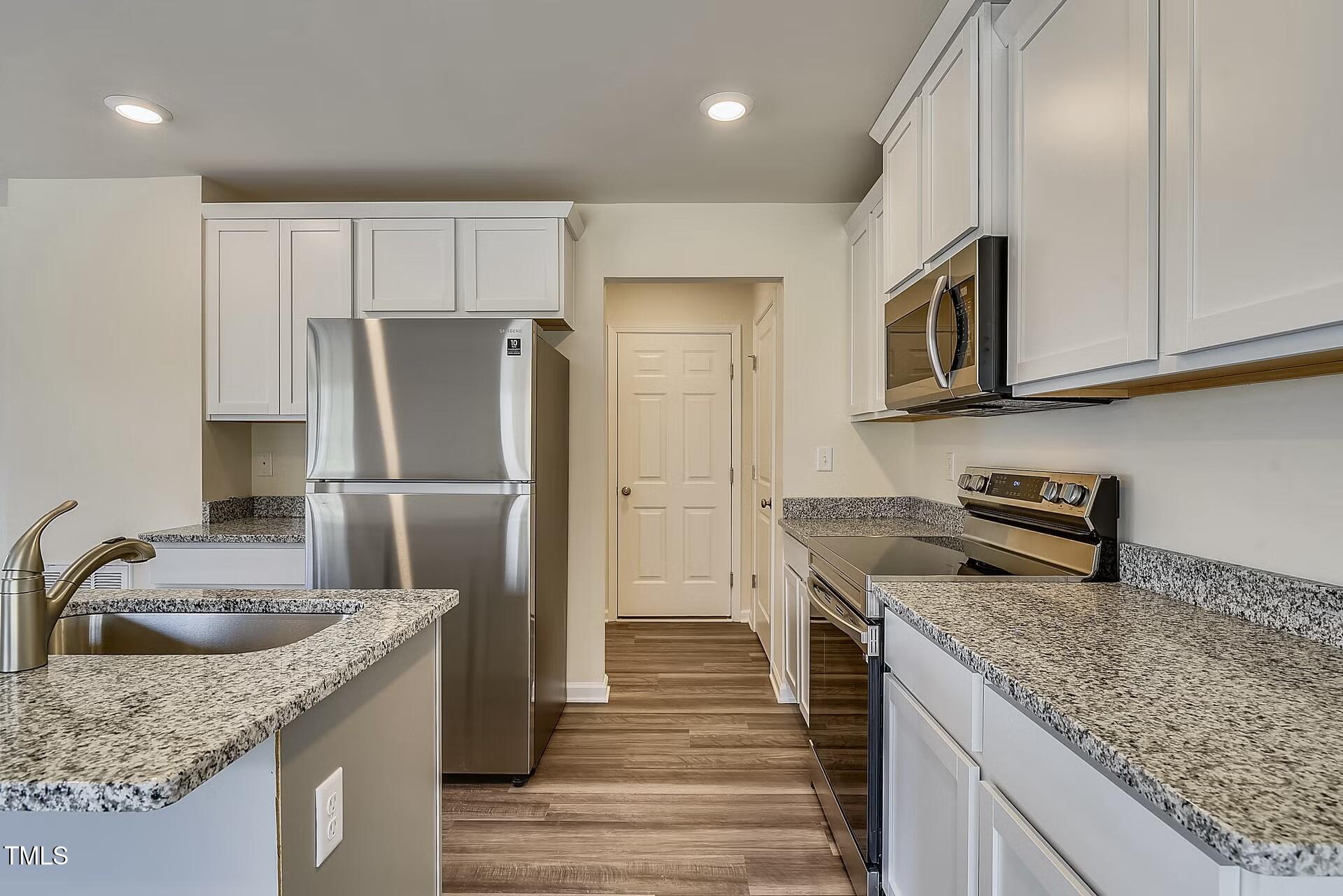 2700 Barrington Drive Raleigh, NC 27610 - Photo 22 of 27 a kitchen with stainless steel appliances granite countertop a sink stove and refrigerator
