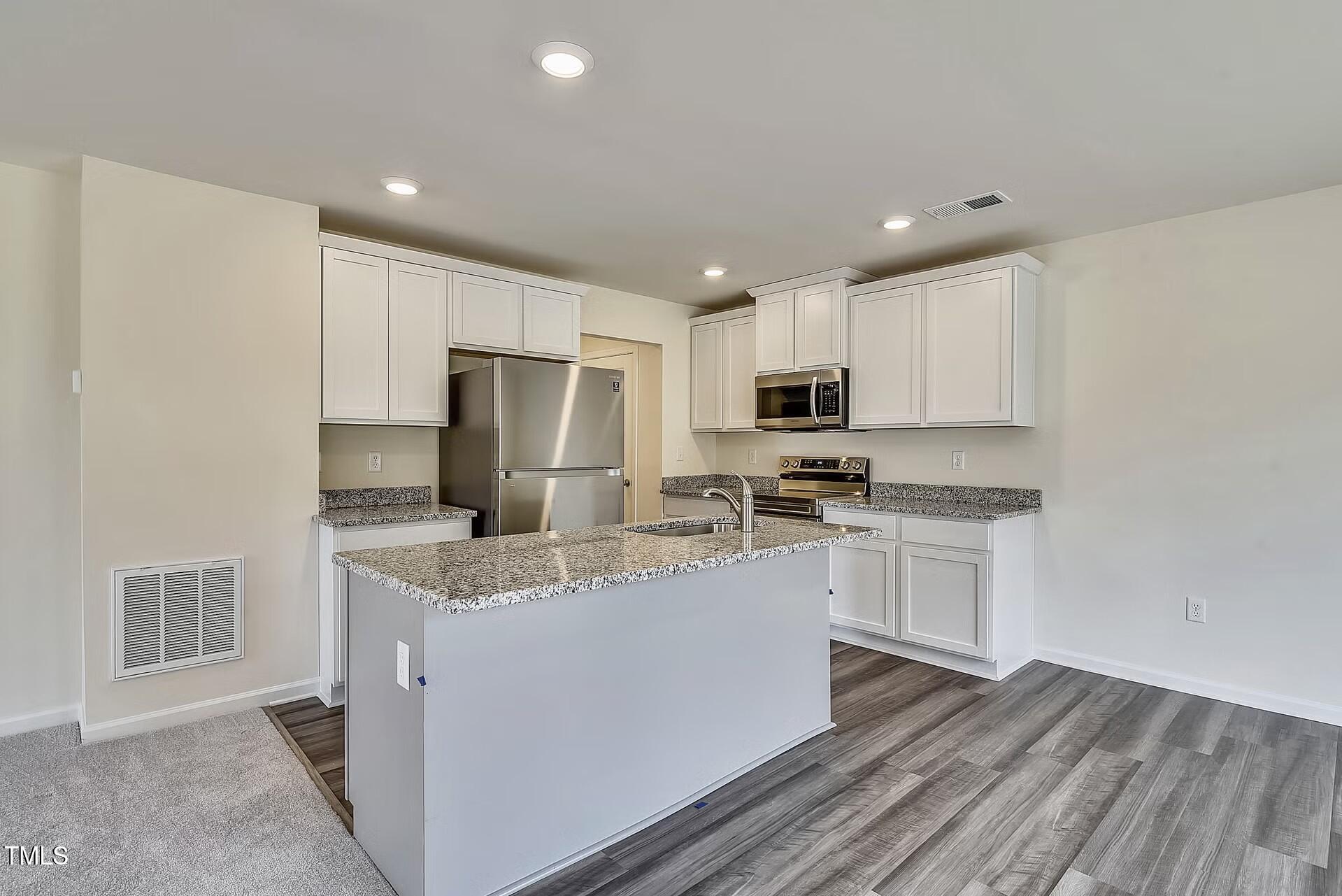 2700 Barrington Drive Raleigh, NC 27610 - Photo 6 of 27 a kitchen with stainless steel appliances granite countertop a refrigerator sink and white cabinets