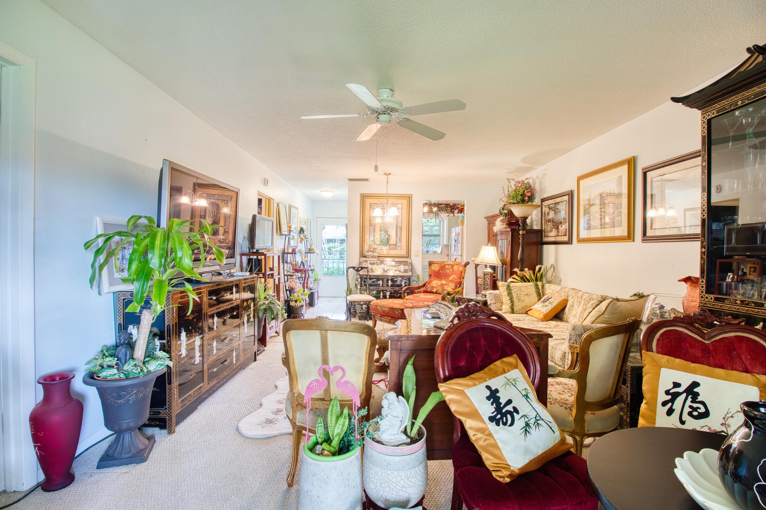 1911 Southwest Palm City Road, Unit J Stuart, FL 34994 - Photo 5 of 42 a living room with furniture potted plant and a chandelier