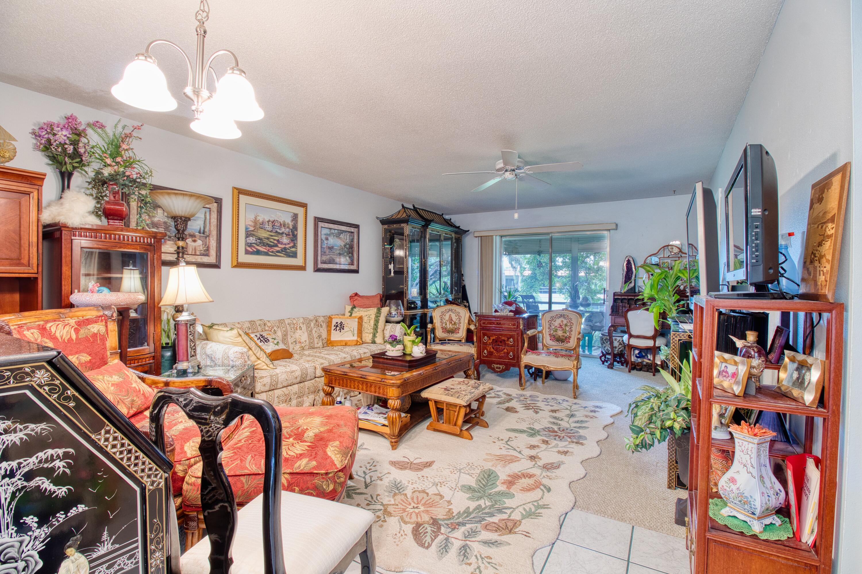 1911 Southwest Palm City Road, Unit J Stuart, FL 34994 - Photo 6 of 42 a living room with patio furniture and a chandelier