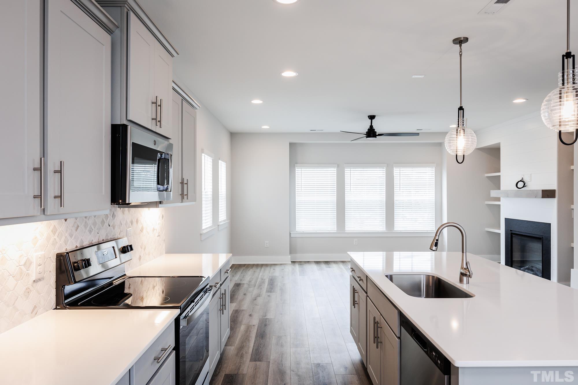 8111 Diversity Way Raleigh, NC 27613 - Photo 6 of 26 a kitchen with granite countertop a stove sink and microwave