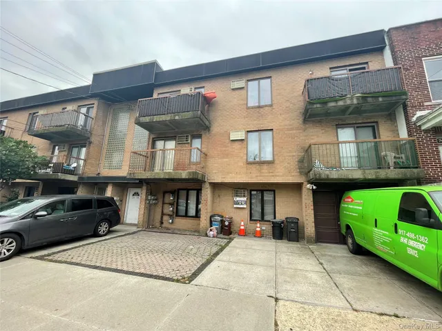 a front view of a house with a garden and parking