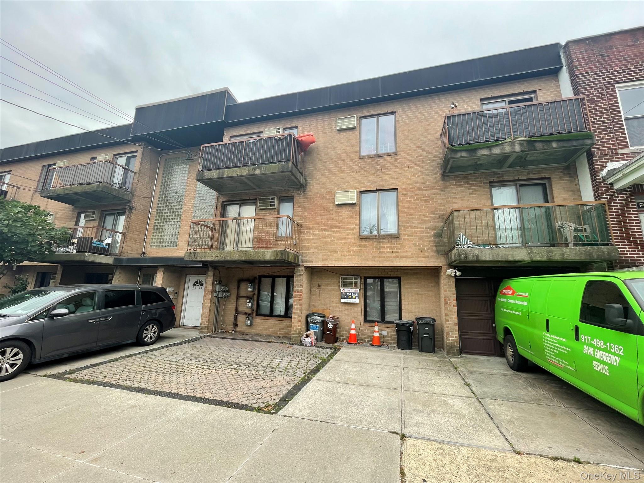 a front view of a house with a garden and parking