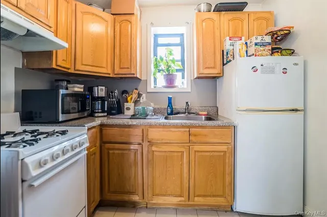 a kitchen with stainless steel appliances granite countertop a refrigerator sink stove and microwave