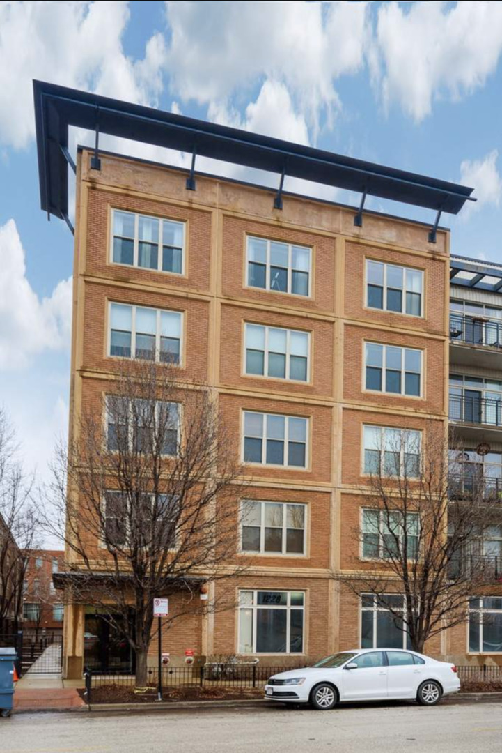 1228 West Monroe Street, Unit 401 Chicago, IL 60607 - Photo 1 of 8 a front view of a building with lot of cars and trees