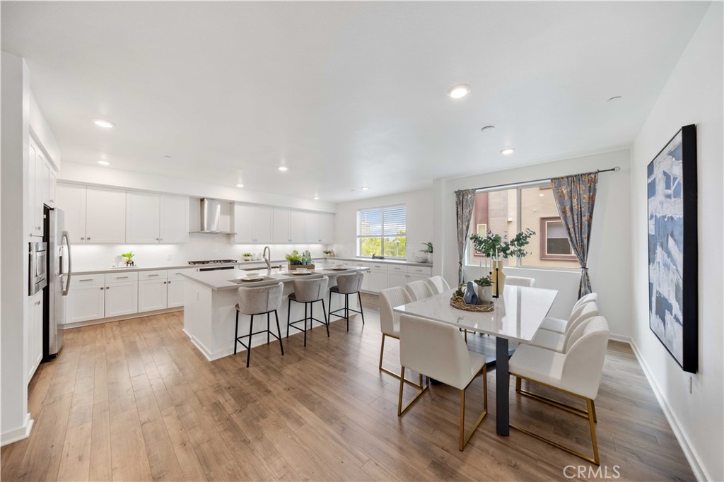 143 Bowery Irvine, CA 92612 - Photo 4 of 32 a view of a dining room with furniture and wooden floor