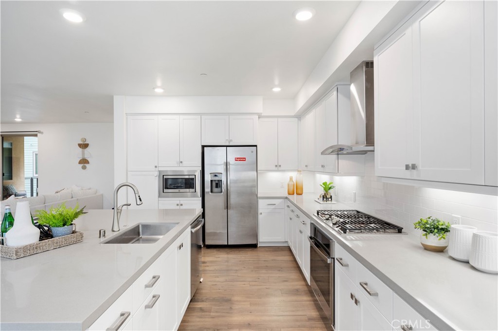 143 Bowery Irvine, CA 92612 - Photo 5 of 32 a kitchen with stainless steel appliances a sink a stove and a refrigerator