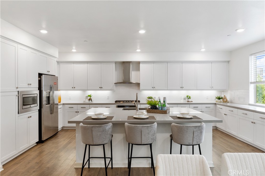 143 Bowery Irvine, CA 92612 - Photo 8 of 32 a kitchen with white cabinets and stainless steel appliances