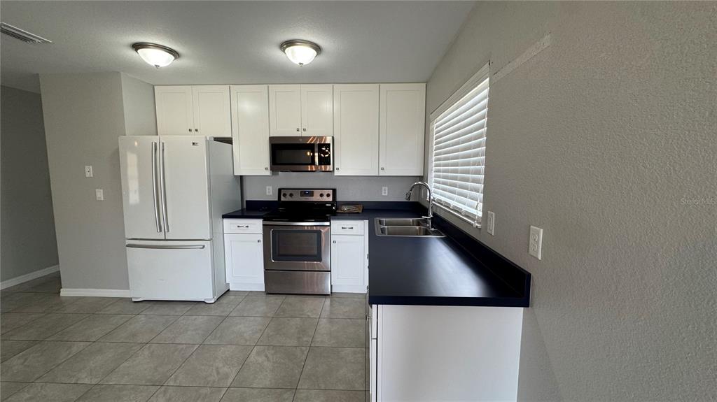4318 Mongite Road North Port, FL 34287 - Photo 5 of 18 a kitchen with stainless steel appliances a refrigerator stove and sink