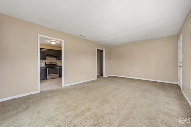 a view of empty room with kitchen