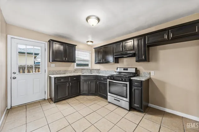 a kitchen with granite countertop a sink and steel appliances