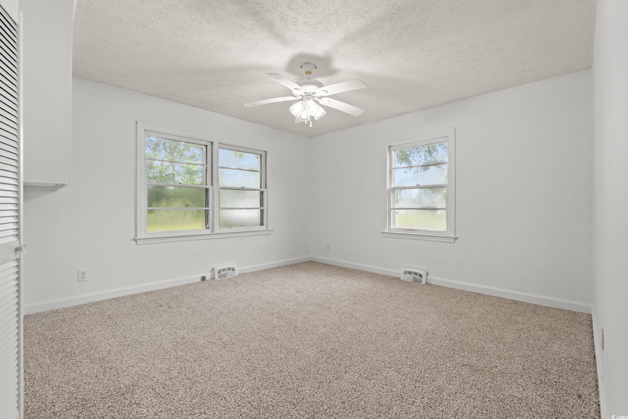 4155 Pinewood Drive Mullins, SC 29574 - Photo 13 of 33 Carpeted spare room with plenty of natural light, a textured ceiling, and ceiling fan