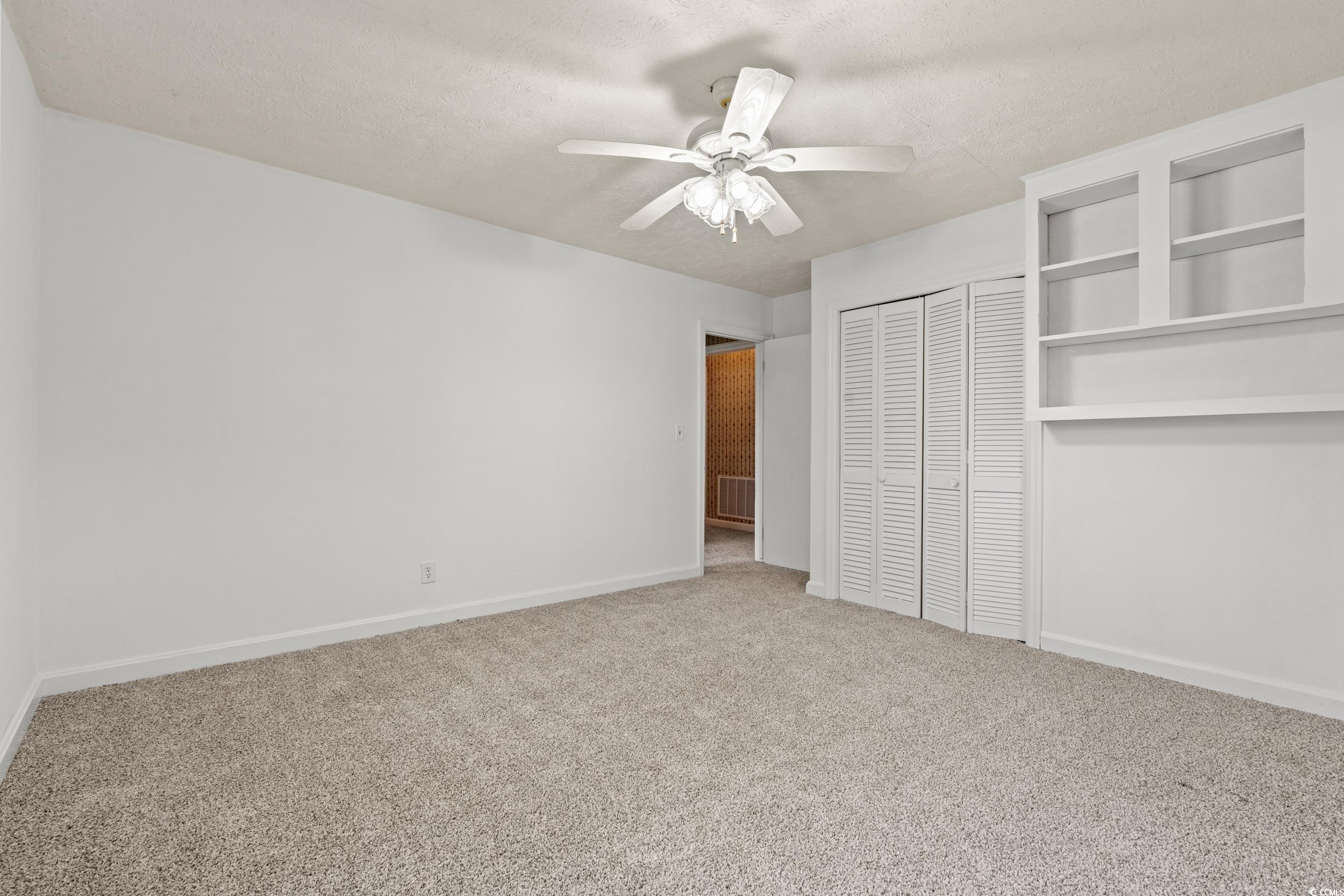 4155 Pinewood Drive Mullins, SC 29574 - Photo 14 of 33 Unfurnished bedroom featuring carpet floors, a closet, a textured ceiling, and a ceiling fan