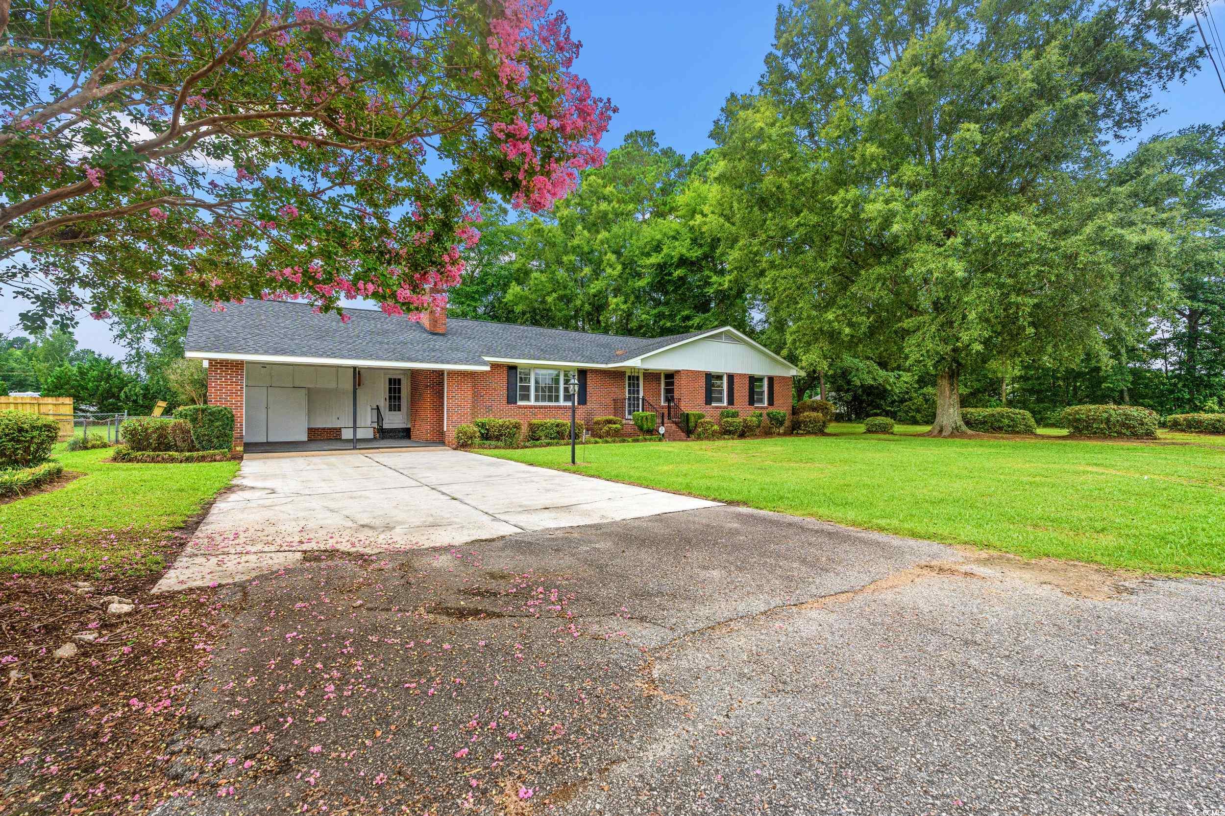 4155 Pinewood Drive Mullins, SC 29574 - Photo 19 of 33 Ranch-style home featuring an attached carport, driveway, brick siding, and roof with shingles