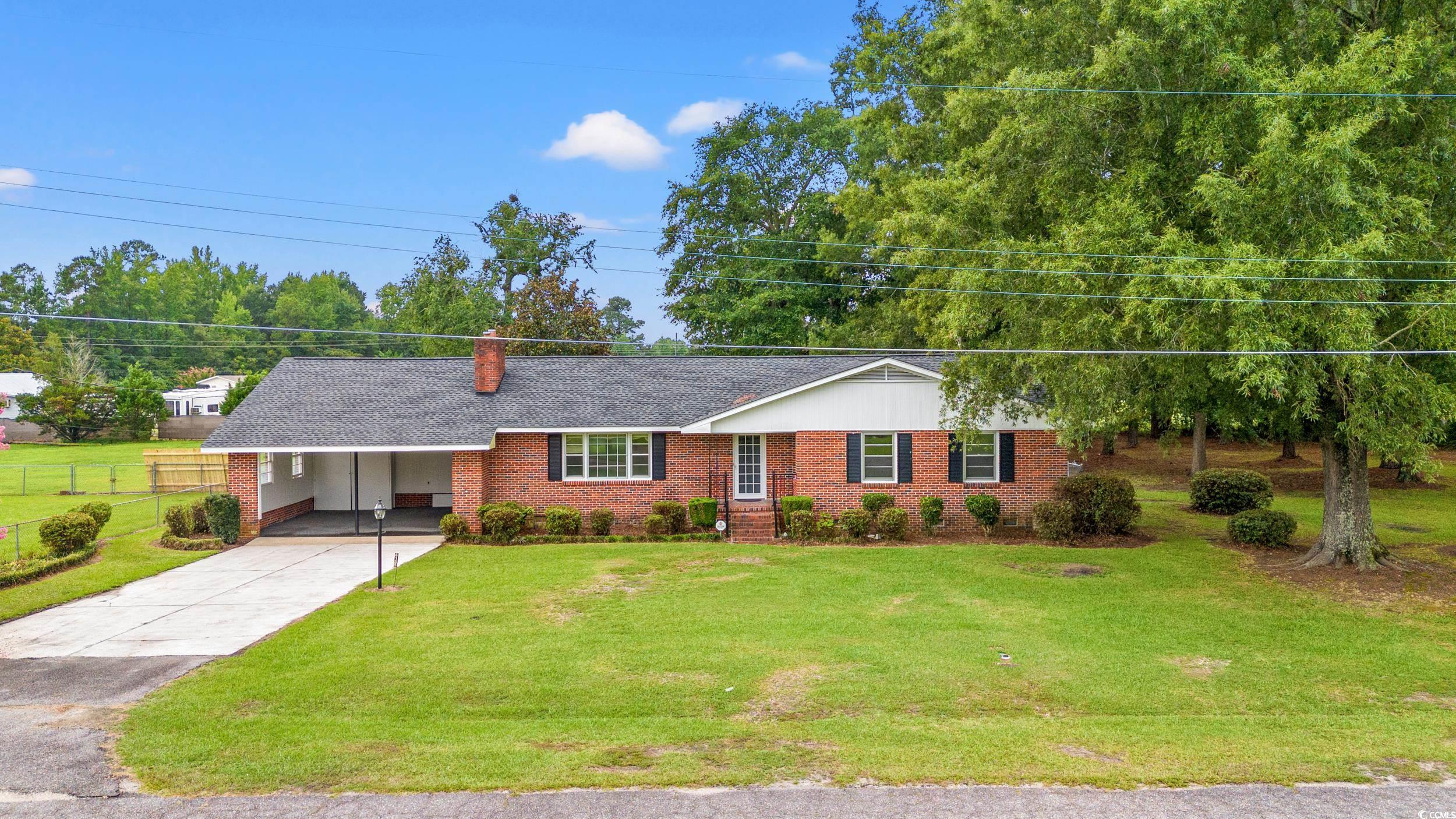 4155 Pinewood Drive Mullins, SC 29574 - Photo 20 of 33 Ranch-style house with driveway, a carport, brick siding, a chimney, and roof with shingles