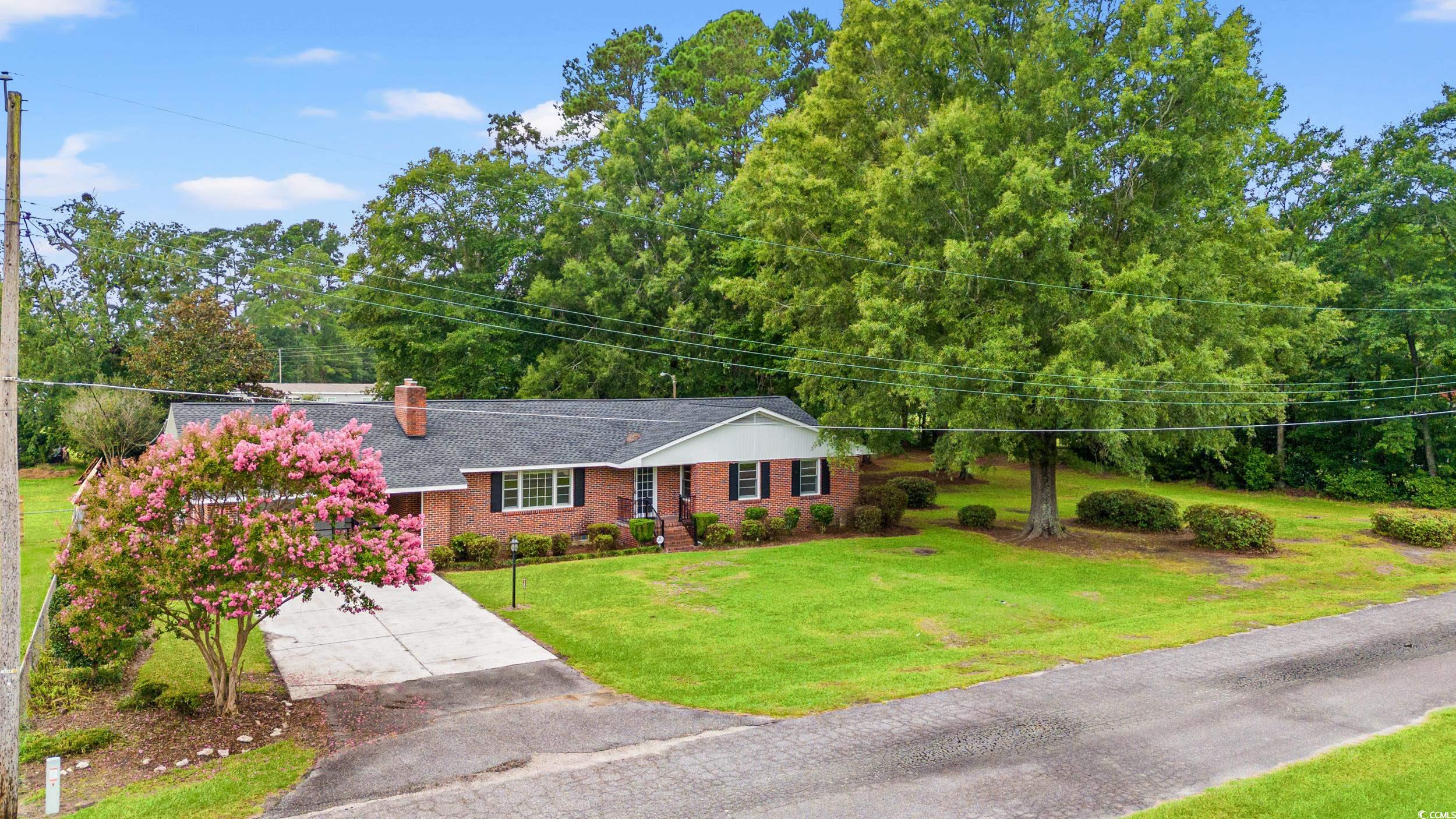 4155 Pinewood Drive Mullins, SC 29574 - Photo 23 of 33 Ranch-style home with brick siding, roof with shingles, driveway, a front lawn, and a chimney