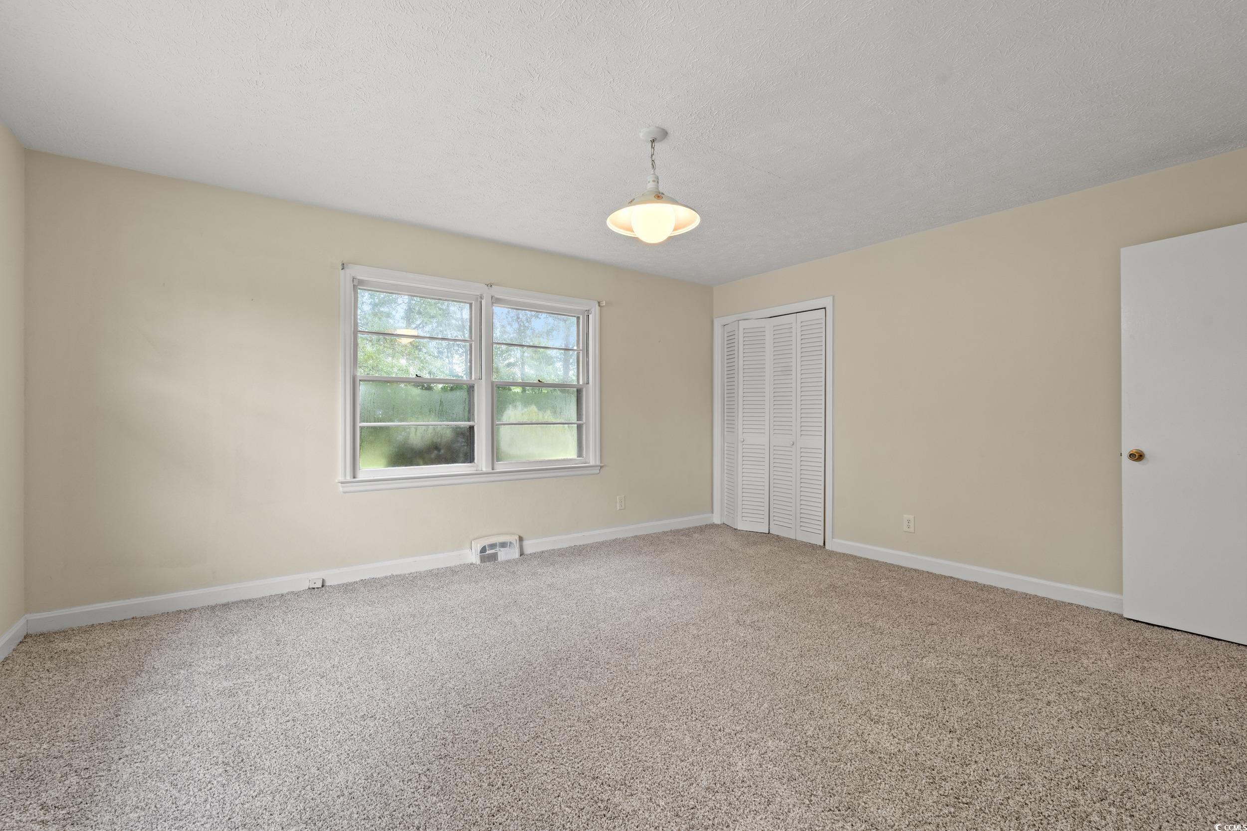 4155 Pinewood Drive Mullins, SC 29574 - Photo 7 of 33 Unfurnished bedroom featuring carpet floors, a closet, and a textured ceiling