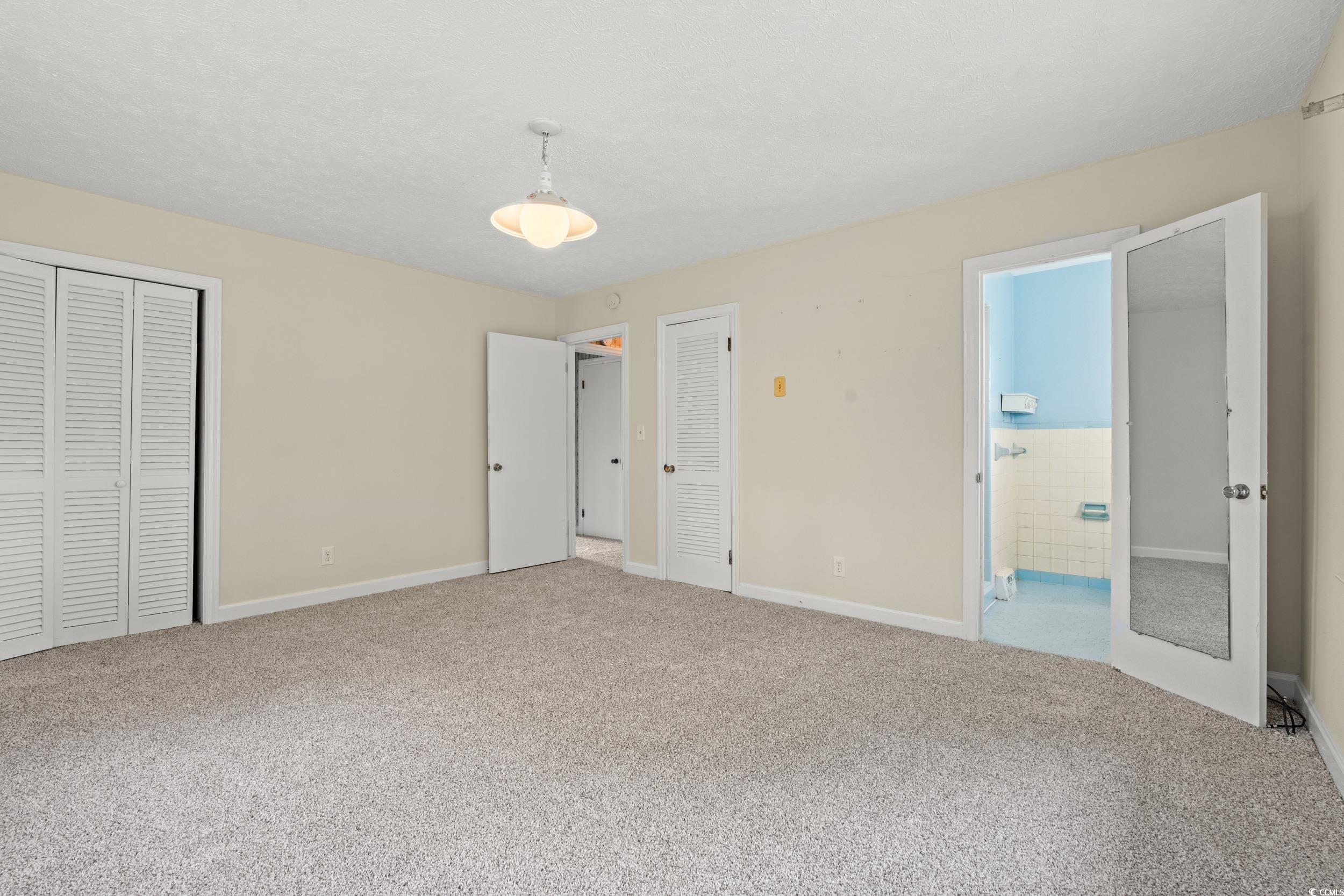 4155 Pinewood Drive Mullins, SC 29574 - Photo 8 of 33 Unfurnished bedroom with carpet, ensuite bath, and a textured ceiling