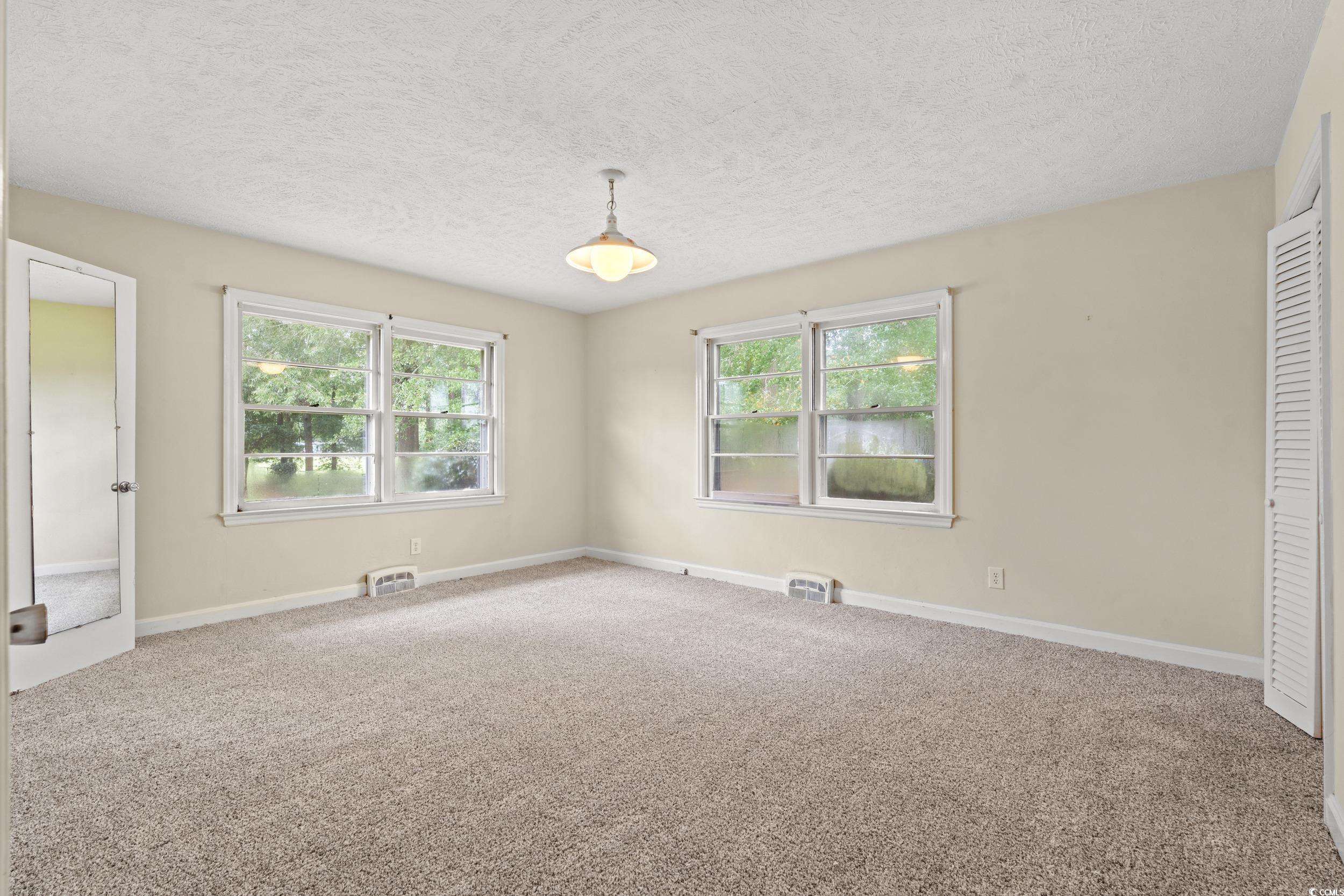 4155 Pinewood Drive Mullins, SC 29574 - Photo 9 of 33 Empty room featuring carpet floors, healthy amount of natural light, and a textured ceiling