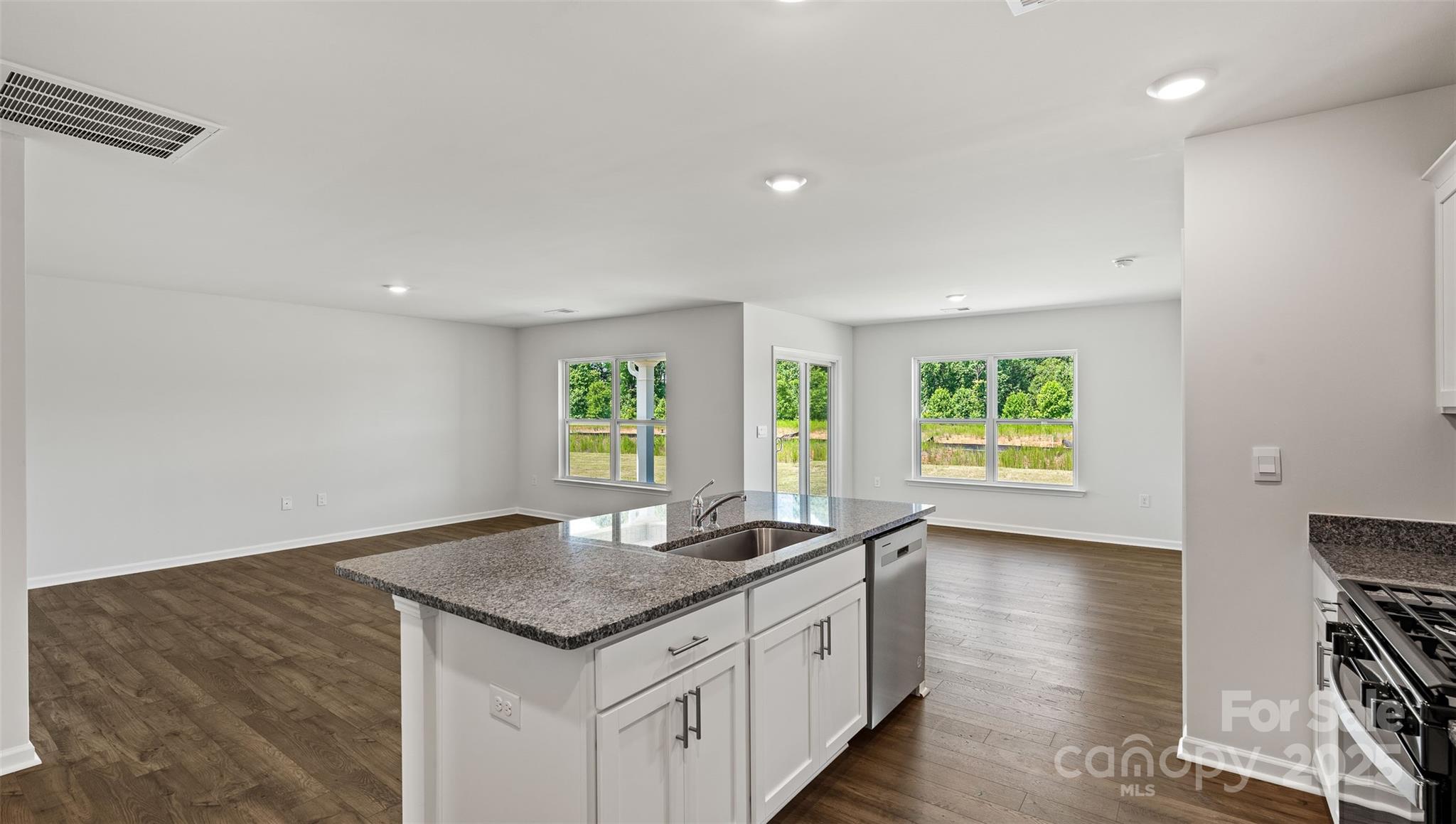 212 Callie River Clyde, NC 28721 - Photo 5 of 25 a kitchen with granite countertop a sink and a wooden floor