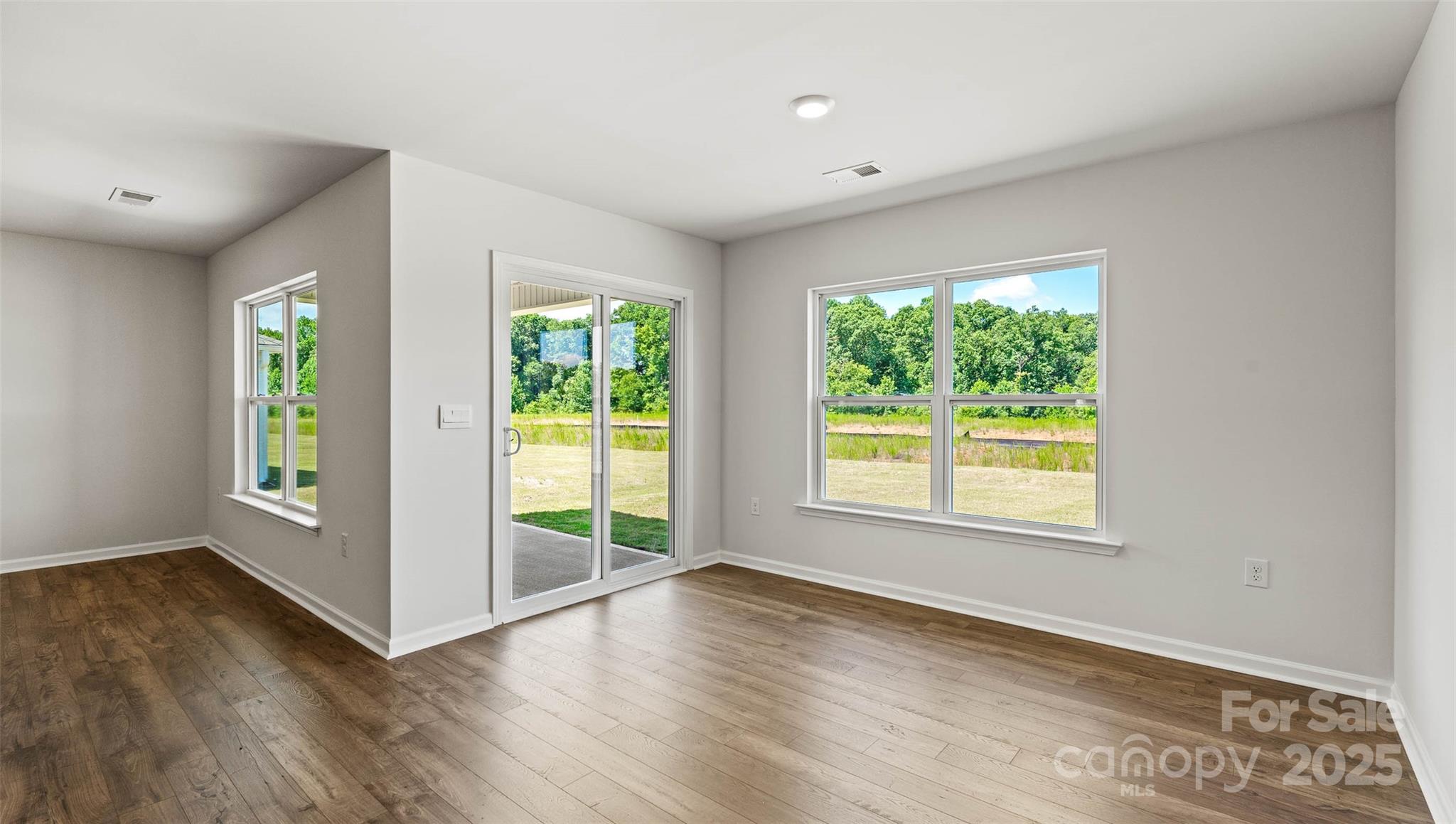 212 Callie River Clyde, NC 28721 - Photo 9 of 25 an empty room with wooden floor and windows