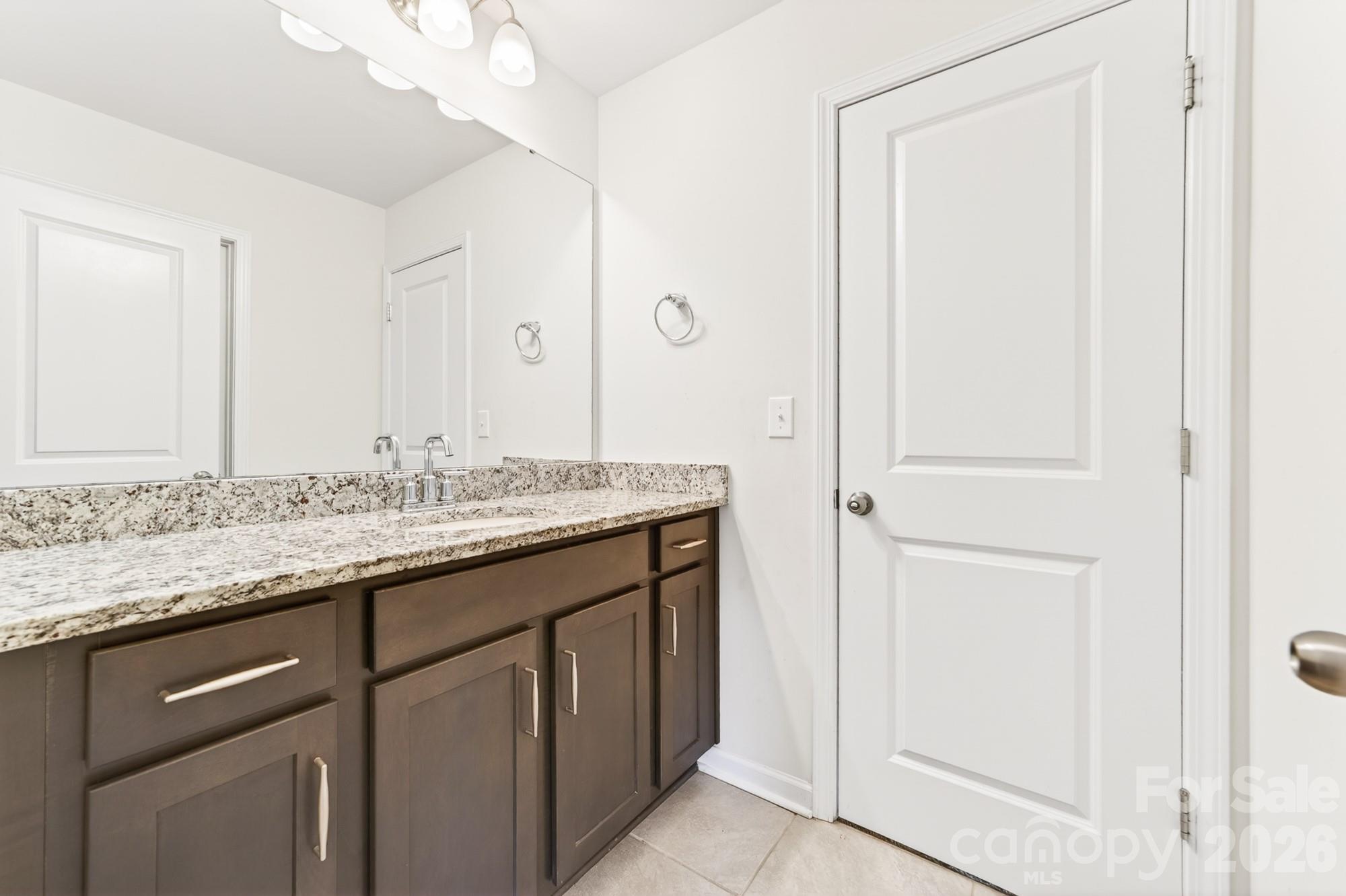 5972 Redwood Pine Road Concord, NC 28027 - Photo 32 of 37 a bathroom with a granite countertop sink and a mirror