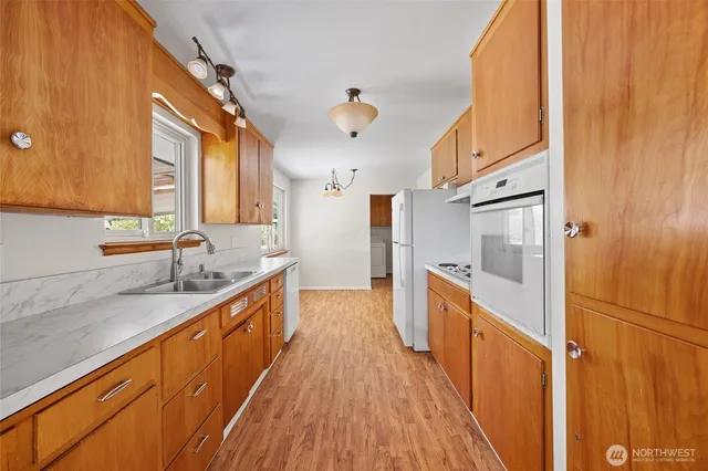 a kitchen with stainless steel appliances granite countertop a sink and wooden cabinets