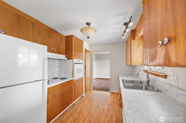 a kitchen with stainless steel appliances granite countertop a sink and a refrigerator