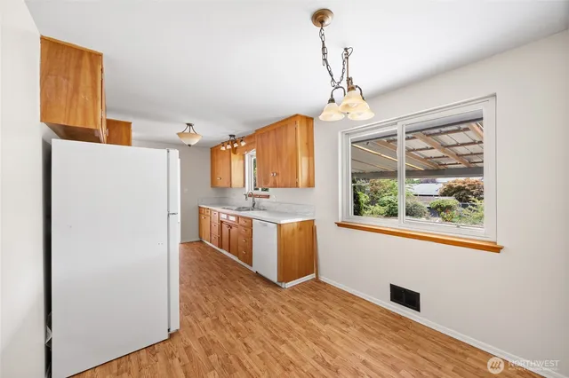a kitchen with refrigerator cabinets and wooden floor