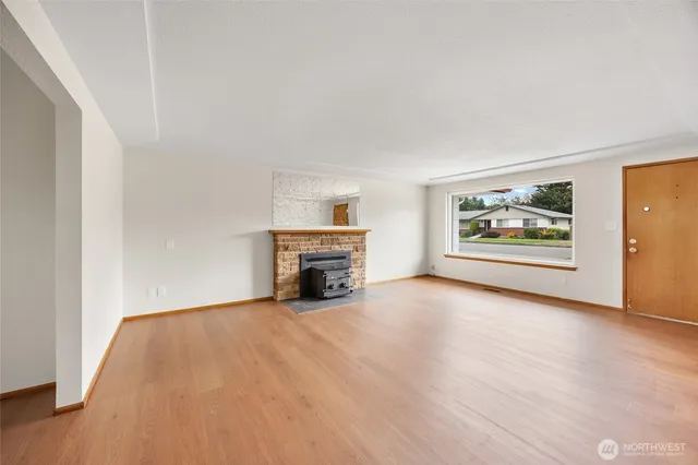 a view of an empty room with a fireplace and a window