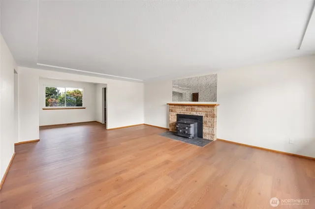 an empty room with floor fireplace and windows