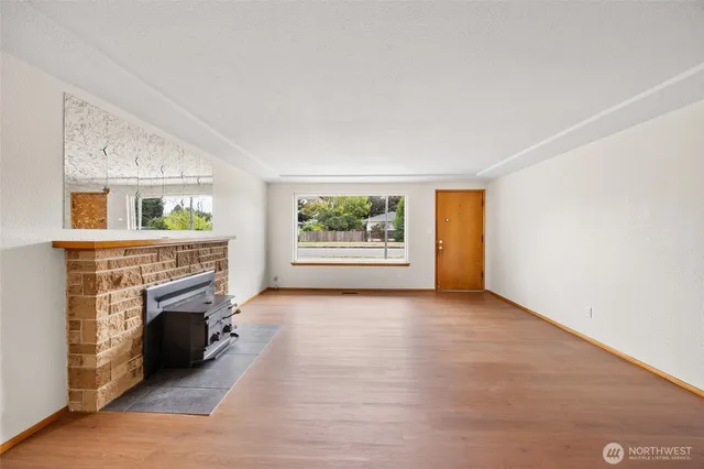 a view of an empty room with window and fireplace