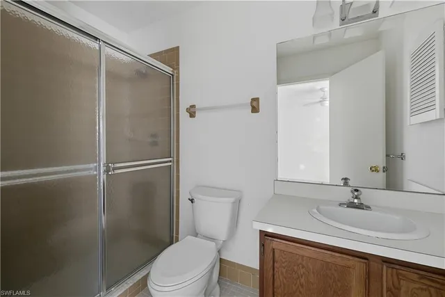 a bathroom with a sink toilet vanity and shower