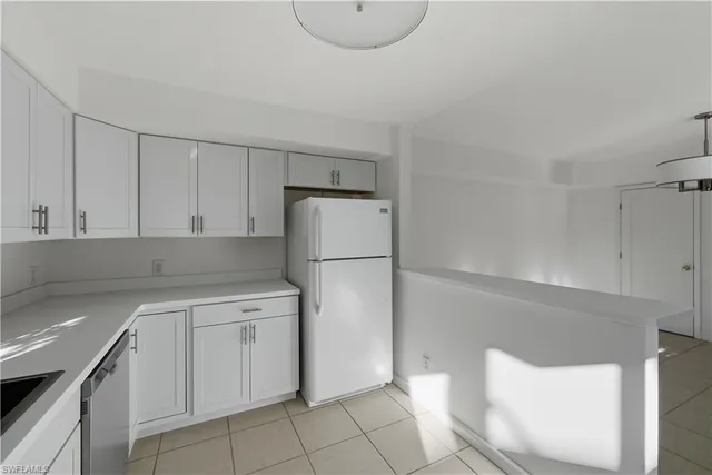 a kitchen with a refrigerator sink and cabinets