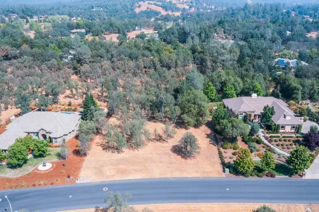 an aerial view of a house with yard and seating space