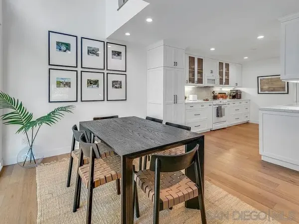 a kitchen with stainless steel appliances granite countertop table chairs stove and cabinets