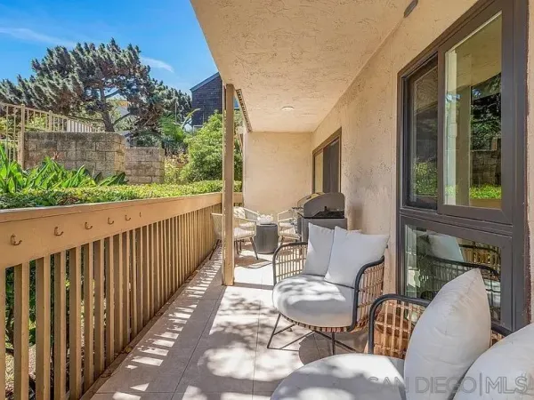 a view of a patio with couches chairs and wooden floor