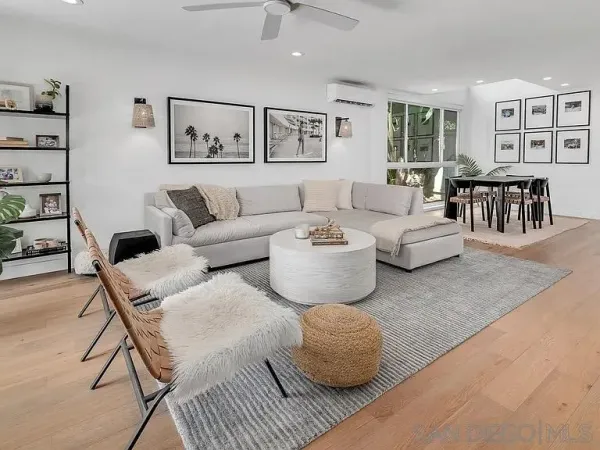 a living room with furniture and paintings on the wall