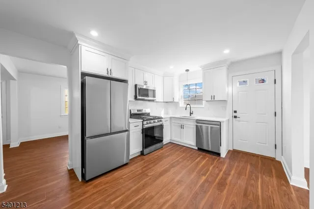a kitchen with a refrigerator sink and cabinets