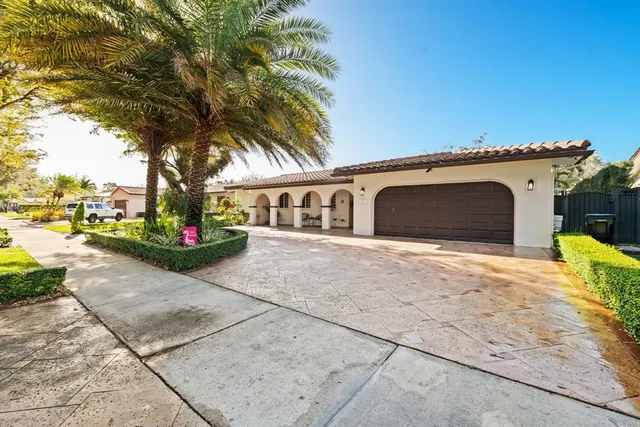 a front view of a house with garden and parking