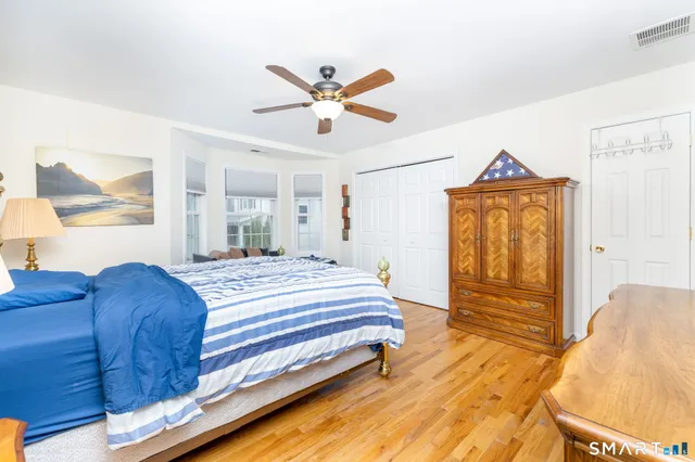 a bedroom with a bed and dresser with mirror